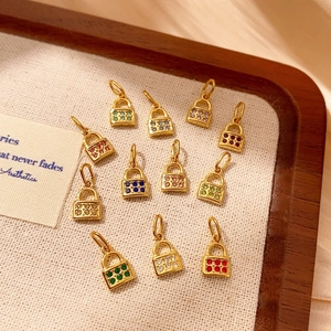 Primer plano de colgantes de candado dorados con circonitas de colores en expositor de joyas