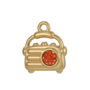 Makroaufnahme von Vintage-Radio-Anhänger mit roten Strasssteinen für DIY-Schmuck