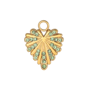 Primer plano de colgante de corazón dorado con textura radiante y cristales verdes