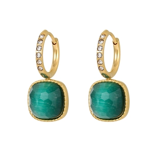 Macro detail of gold hoop earrings with small zircons and a square green gemstone drop