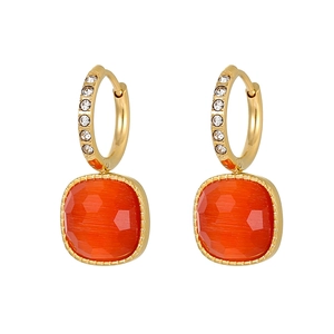 Detail of square orange gemstone earrings with gold rim and cubic zirconia accents