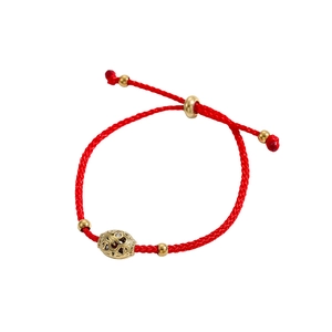 Detail eines roten geflochtenen Armbands mit goldenem Anhänger und Schiebeverschluss