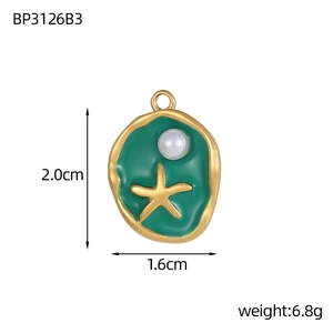 Detailed macro of irregular gold starfish pendant with green enamel and center pearl