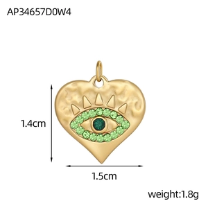 Détail du pendentif cœur avec motif œil, zircons verts et texture martelée dorée