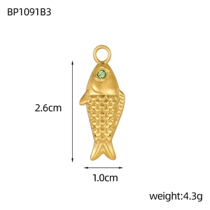 Detail van zeemeermin hanger met gouden schubben en groene edelsteen oog