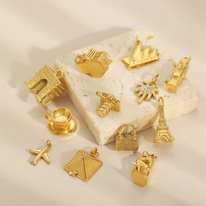 Golden vintage metal charms featuring world landmarks and travel icons on marble base