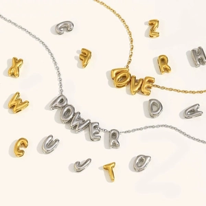 Detailed view of hollow 18K gold and silver letter charms for DIY jewelry necklaces