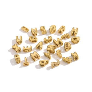 Macro shot of 26 alphabet letters 18K gold plated hollow beads for jewelry making