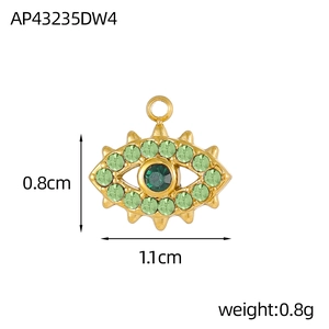 Vue macro du pendentif œil maléfique doré avec cristaux verts et détails 1,1cm x 0,8cm