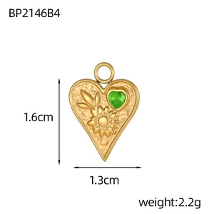 Vue détaillée d'un pendentif cœur doré 1,6x1,3cm avec zircon vert et relief floral