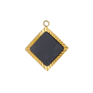 Vue macro d'un pendentif carré doré avec insert noir et gravures rayonnantes