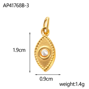 Dettaglio di un ciondolo a forma di occhio dorato con perla, misura 1,9 cm x 0,9 cm
