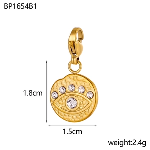 Dettaglio del ciondolo Evil Eye dorato con strass bianchi e chiusura a moschettone