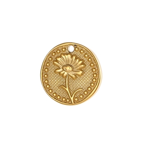 Macro detail of golden flower pendant with floral relief and textured grid pattern