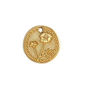 Macro detail of a golden vintage flower relief pendant made of stainless steel material