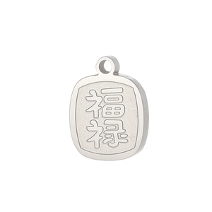 Macro detail of silver stainless steel pendant with engraved traditional Chinese characters