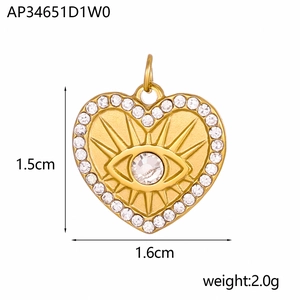 Dettaglio ciondolo cuore dorato con rilievo malocchio e zirconi, misura 1,6cm x 1,5cm