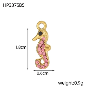 Detailed view of seahorse pendant with pink zircons and gold finish 1.8cm x 0.6cm