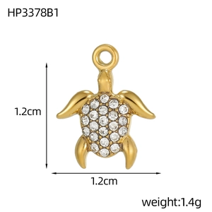 Detail view of a gold turtle pendant with white rhinestones and size measurements