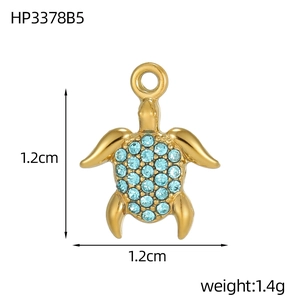 Detailed macro view of sea turtle pendant with gold plating and blue cubic zirconia stones