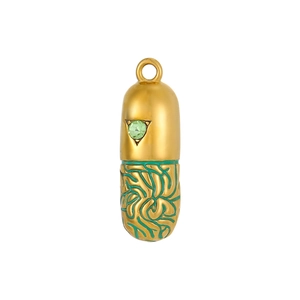 Macro shot of gold and green capsule pendant featuring star-shaped gem and enamel patterns