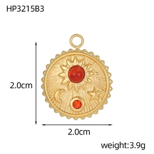 Detailed view of a gold sun and moon pendant with a red stone and 2cm size mark