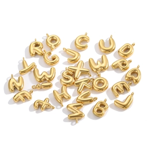 Close-up of golden 3D bubble letter pendants with polished mirror finish for DIY jewelry