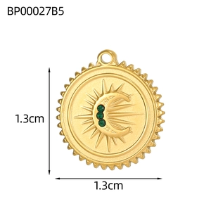 Dettaglio del ciondolo sole e luna dorato da 1,3 cm con pietre di zircone verde