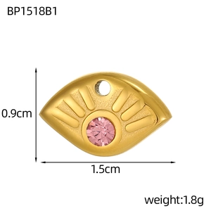 Vue macro du pendentif œil doré avec strass rose et les dimensions de taille