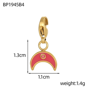 Detail view of a 1.3cm red enamel moon charm with lobster clasp and pink crystal accent