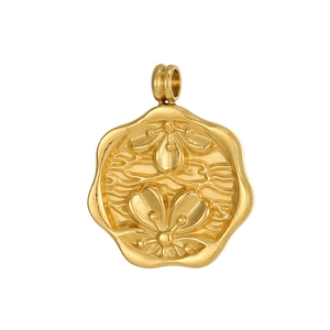 Macro detail of a vintage gold floral embossed pendant with scalloped edges and polished finish