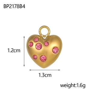 Vue macro d'un pendentif cœur plaqué or avec strass roses, mesurant 1,2 cm par 1,3 cm