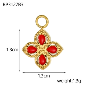 Dettaglio pendente quadrifoglio dorato con pietre rosse, misura 1,3 cm e peso 1,3 g