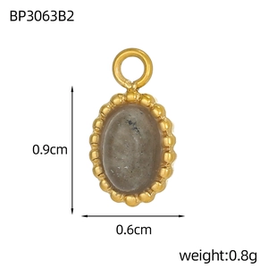 Macro view of a 0.9cm oval turquoise pendant with gold beaded edging and grey stone inlay