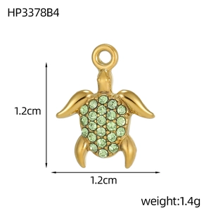 Macro detail of a sea turtle pendant with green zirconia stones and size measurements