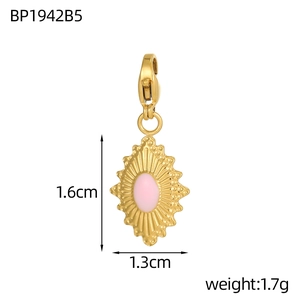 Macro shot of gold stainless steel diamond pendant with pink enamel eye and lobster clasp