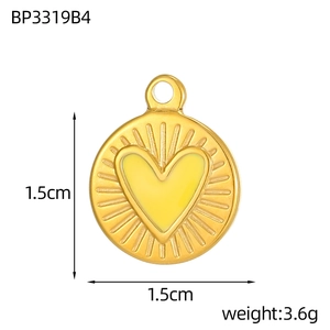 Dettaglio di un ciondolo rotondo dorato da 1,5 cm con cuore giallo e texture