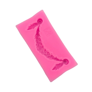 Pink silicone fondant mold with holly leaf and berry vine patterns for cake decorating