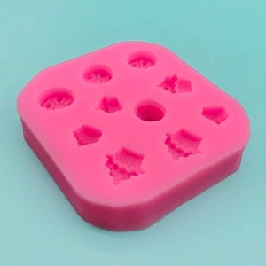 Pink silicone mold for mini cupcakes and chocolates on a high-contrast blue background