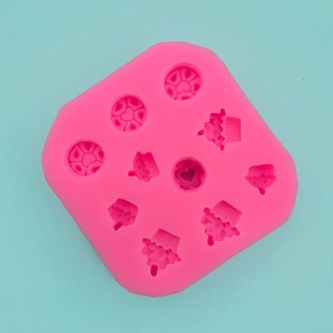 Detailed macro view of 9-cavity pink silicone mold featuring heart and cupcake shapes