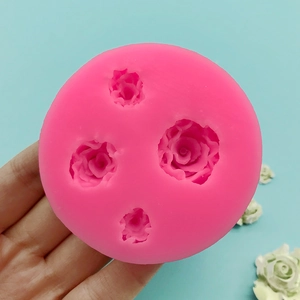 Pink silicone mold featuring four various sized rose flower shapes for cake decorating