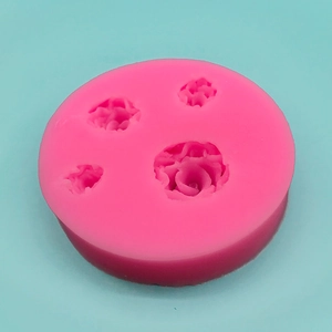 Pink silicone mold featuring four various rose flower designs for cake and fondant baking