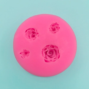 Detail of a pink silicone mold featuring four 3D rose patterns for baking and DIY