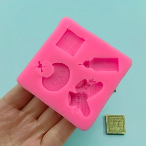 Pink silicone baby mold for fondant with bottle shapes and green finished product example