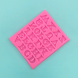 Macro detail of pink silicone mold featuring 26 textured capital letters for cake decor