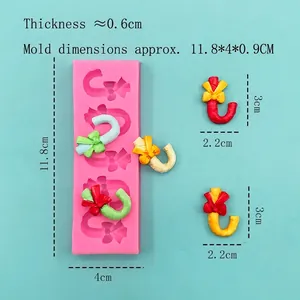 Pink silicone fondant mold for Christmas candy cane shapes with bow decoration tools