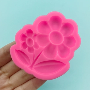 Pink silicone sunflower mold for fondant and cake decorating on blue background