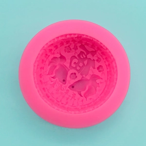 Macro detail of round pink silicone mold with koi fish and Fu character relief