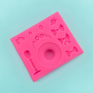 Detail of pink silicone mold with bow, flower, and leaf patterns for fondant cake decor