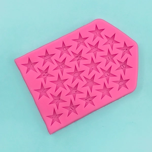 Macro detail of pink star-shaped silicone mold featuring letters and numbers for baking